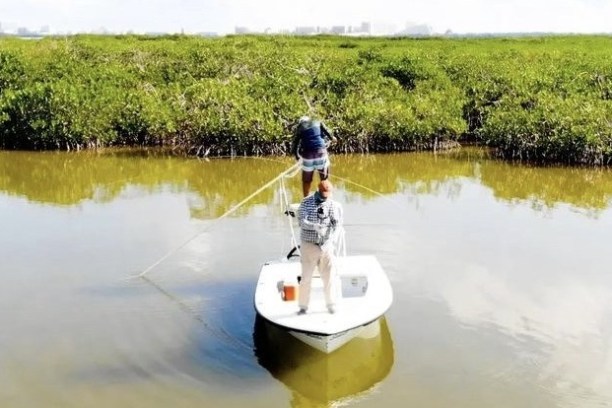a man drinking from a lake