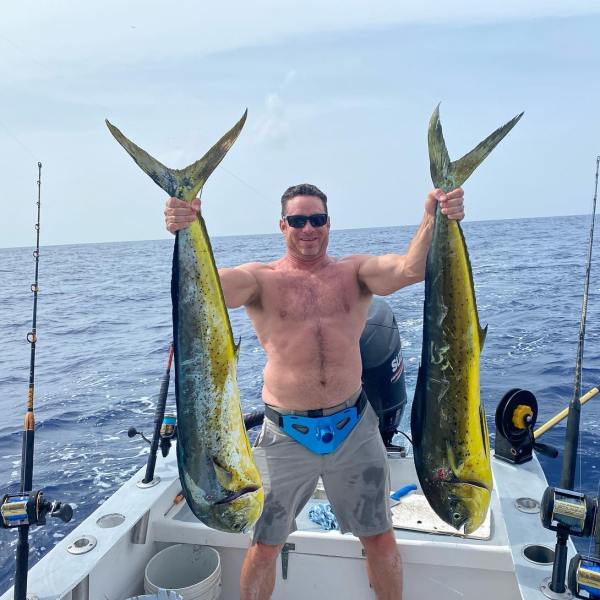 a man holding a fish on a boat