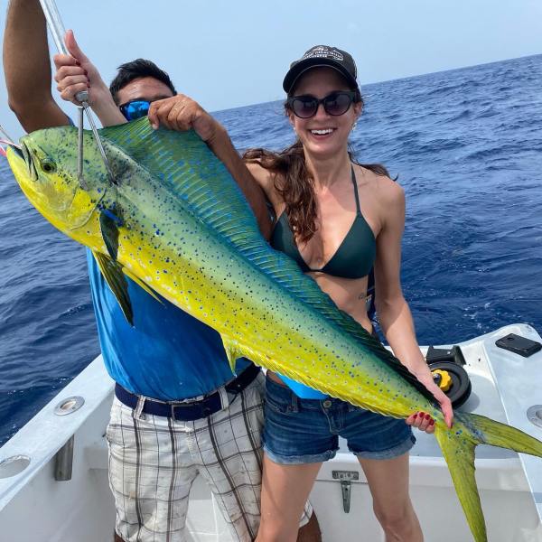 a person holding a fish in the water