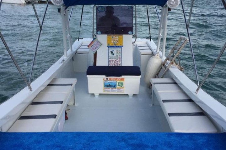 a blue and white boat sitting next to a body of water