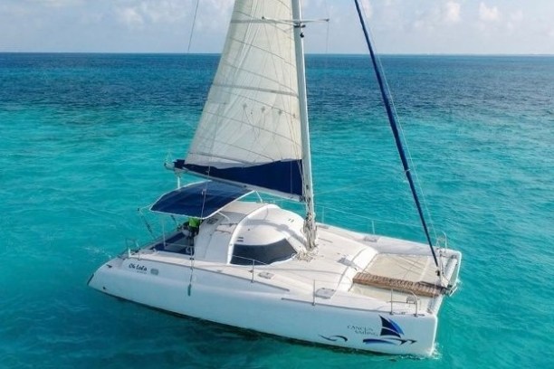 a blue and white boat sitting next to a body of water