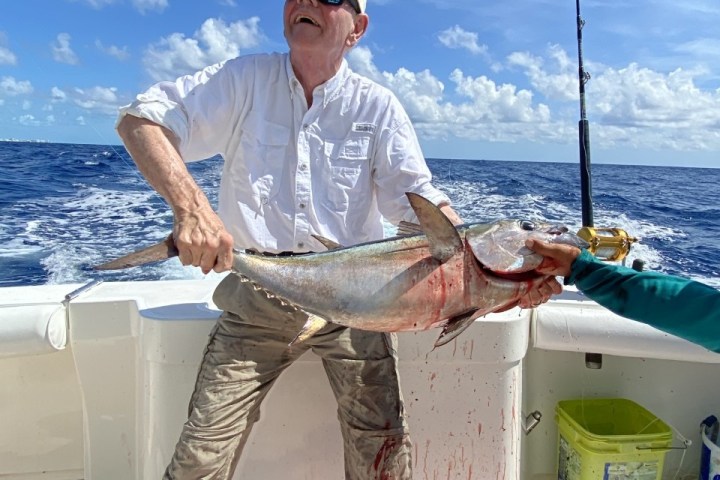 a man holding a fish in the water