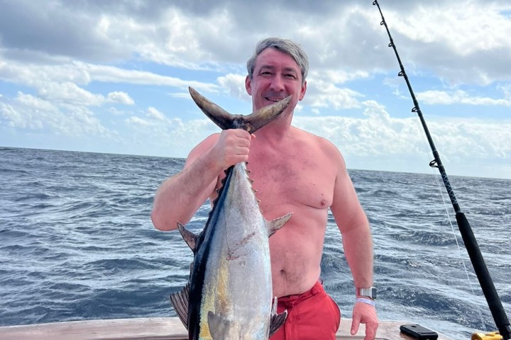 a man holding a fish in the water