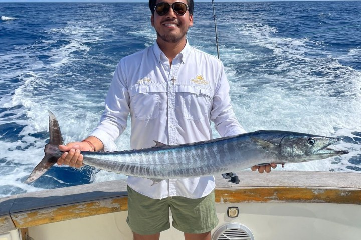 a man holding a fish in the water