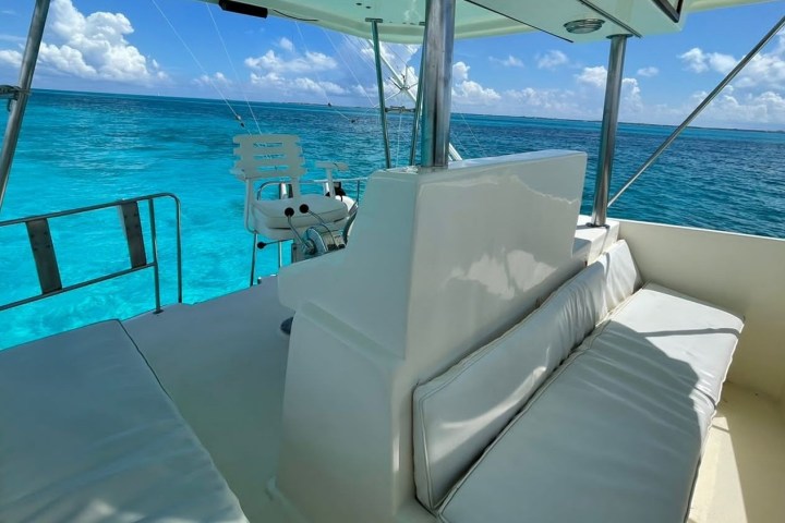 a blue and white boat sitting next to a body of water