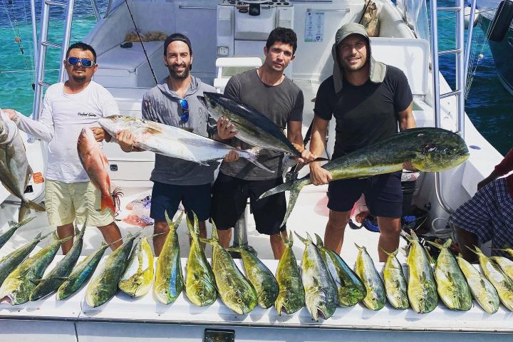 a group of people standing next to a fish on a boat