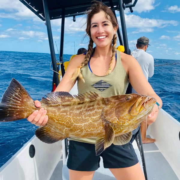 a woman standing next to a body of water