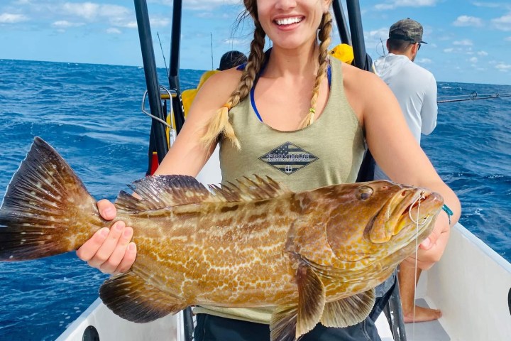 a woman standing next to a body of water