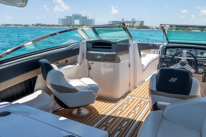 a blue and white boat sitting next to a body of water