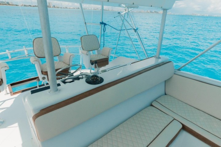 a blue and white boat sitting next to a body of water