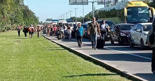 Cancun Airport Traffic a group of people walking on the side of a road