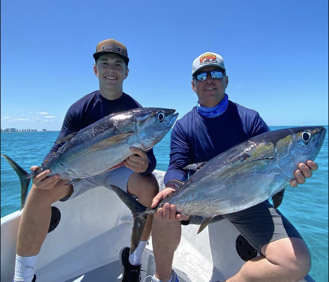 Blackfintuna Two anglers proudly holding two large blackfin tuna caught on a fishing charter in Cancún, Mexico.