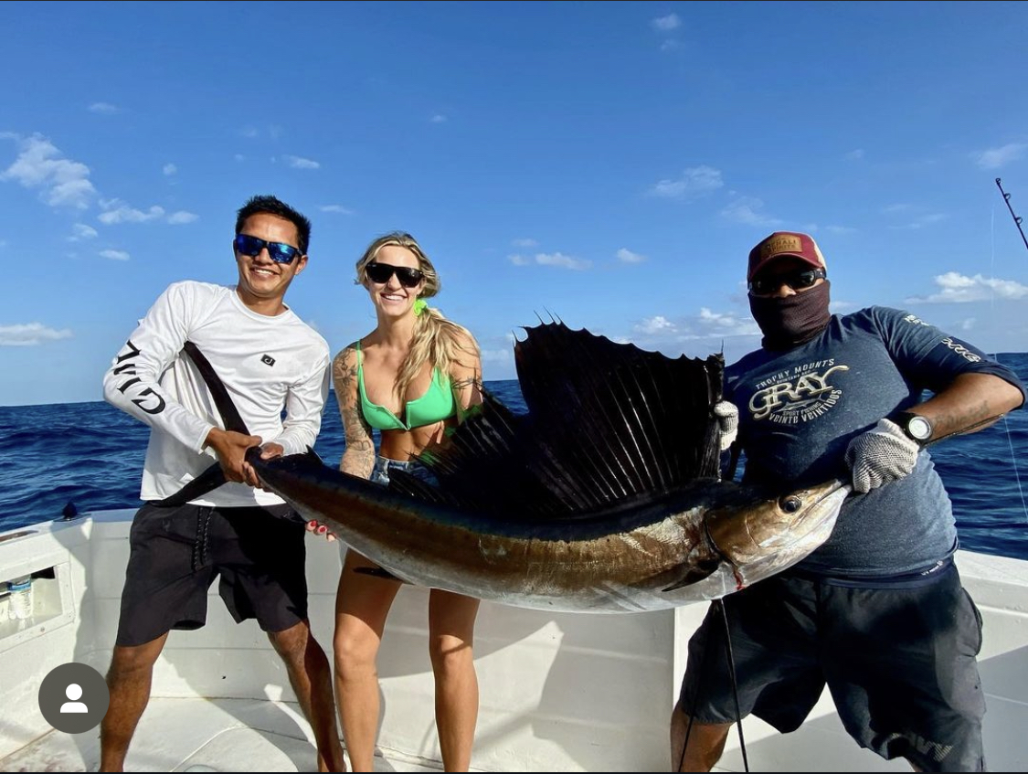 sailfish Fishing charter girl holding a sailfish on a boat during a Cancun deep sea fishing trip
